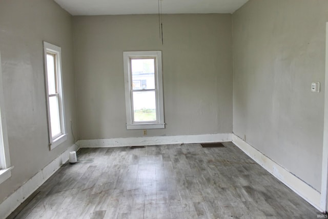 spare room featuring hardwood / wood-style flooring and plenty of natural light