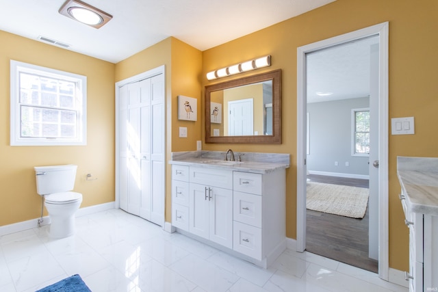 bathroom featuring wood-type flooring, vanity, and toilet