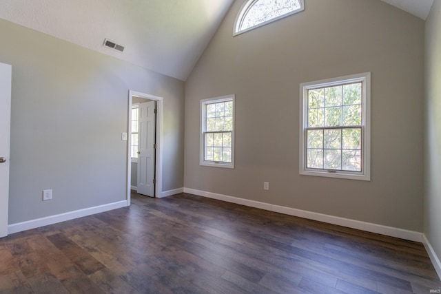 unfurnished room featuring a healthy amount of sunlight, dark hardwood / wood-style floors, and high vaulted ceiling