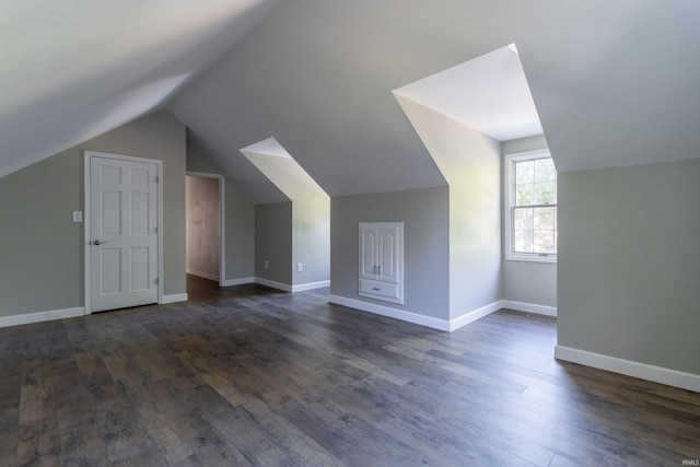 bonus room with lofted ceiling and dark hardwood / wood-style flooring