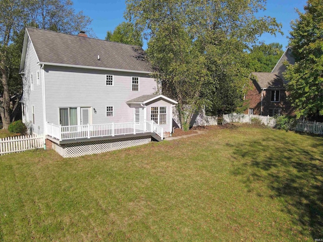 back of property with a wooden deck and a lawn