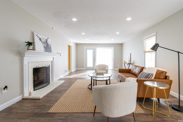 living room with a fireplace and dark wood-type flooring