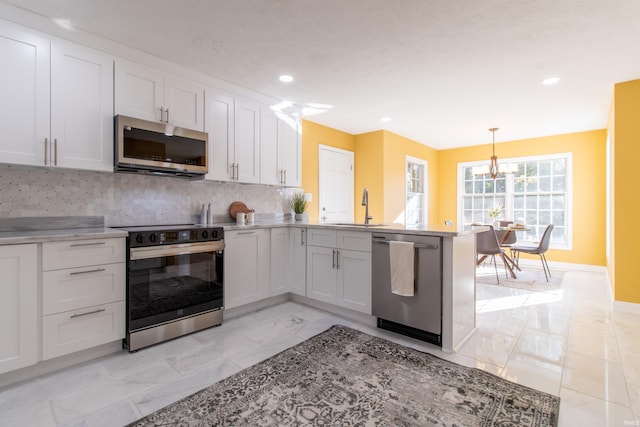 kitchen featuring sink, white cabinets, hanging light fixtures, decorative backsplash, and stainless steel appliances