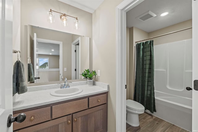 full bathroom featuring wood-type flooring, shower / bath combo, vanity, and toilet