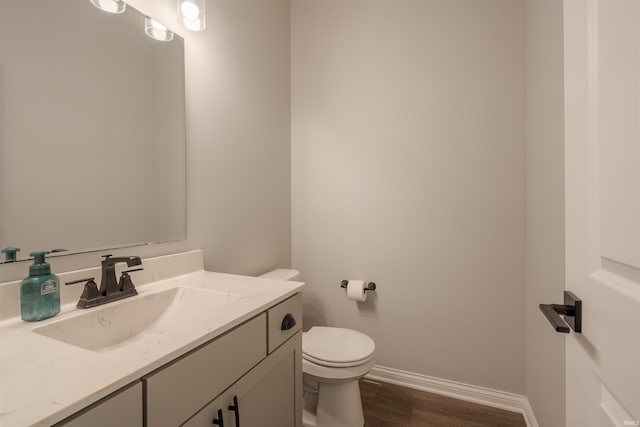 bathroom with vanity, toilet, and hardwood / wood-style flooring