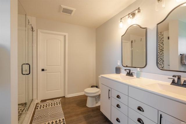 bathroom with walk in shower, hardwood / wood-style flooring, vanity, and toilet