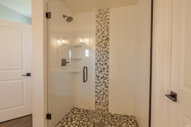 bathroom featuring hardwood / wood-style flooring and a shower with door