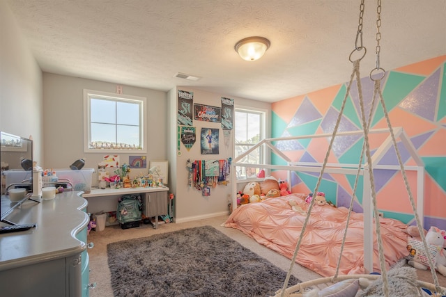 bedroom with multiple windows, carpet flooring, and a textured ceiling