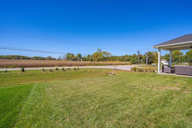 view of yard featuring outdoor lounge area, a rural view, and a patio