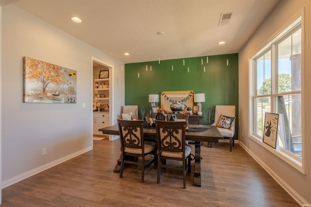 dining area with hardwood / wood-style flooring and built in features