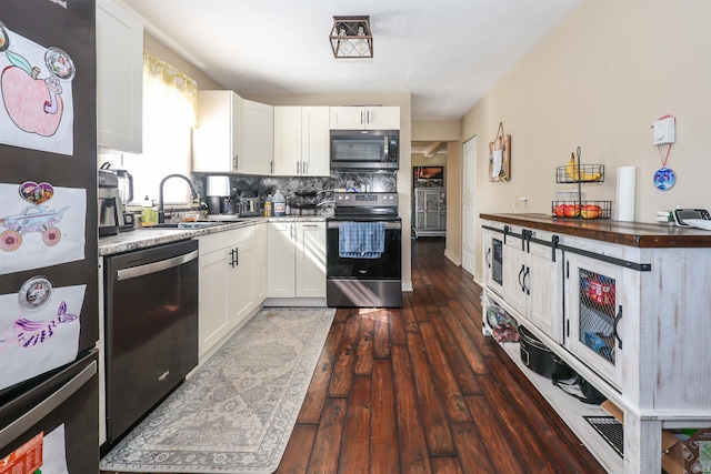 kitchen featuring appliances with stainless steel finishes, white cabinetry, dark hardwood / wood-style flooring, and sink