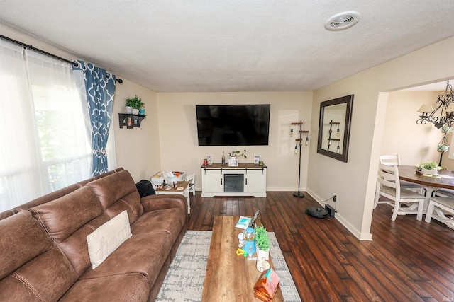 living room with a textured ceiling and dark hardwood / wood-style flooring