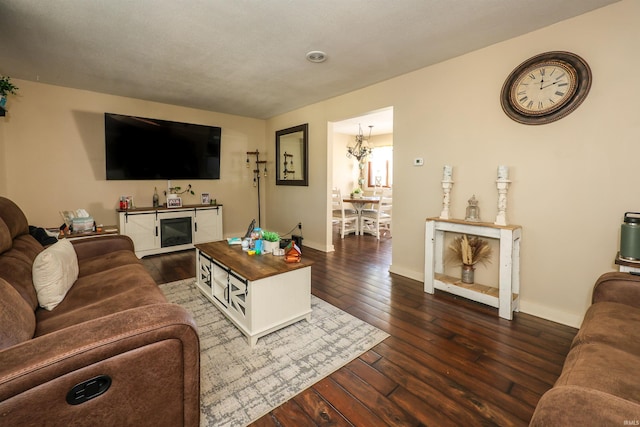 living room with a notable chandelier and dark hardwood / wood-style flooring