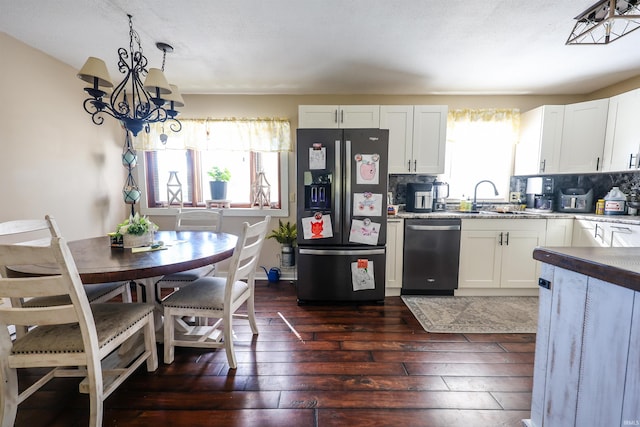 kitchen with white cabinets, appliances with stainless steel finishes, and a healthy amount of sunlight