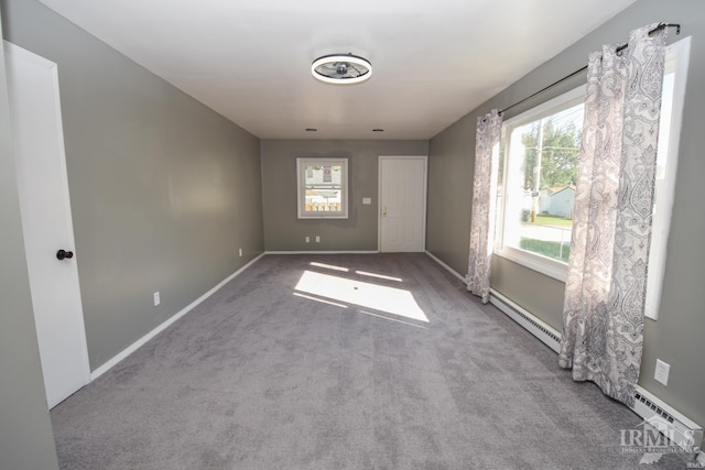 carpeted empty room with baseboard heating