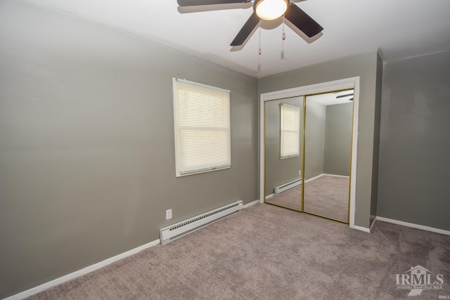 unfurnished bedroom with ceiling fan, a baseboard heating unit, light colored carpet, and a closet