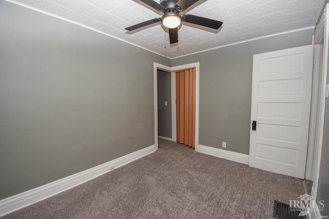 carpeted spare room with crown molding and ceiling fan