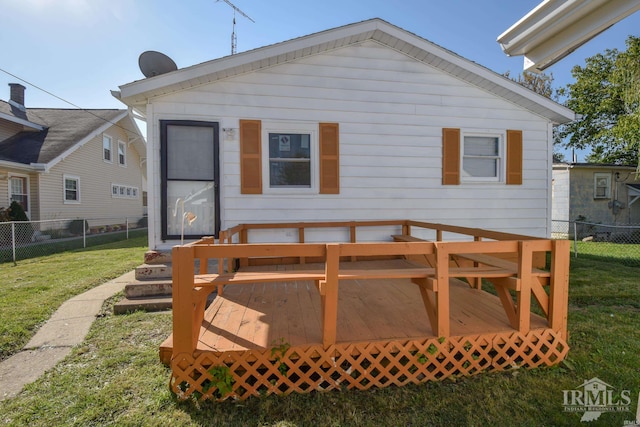 rear view of property featuring a wooden deck and a lawn