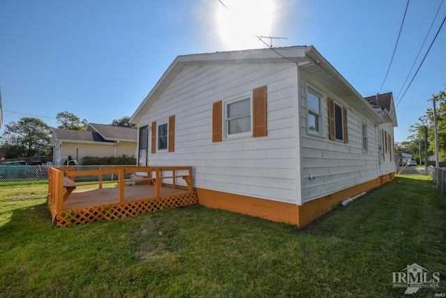 back of property with a yard and a deck