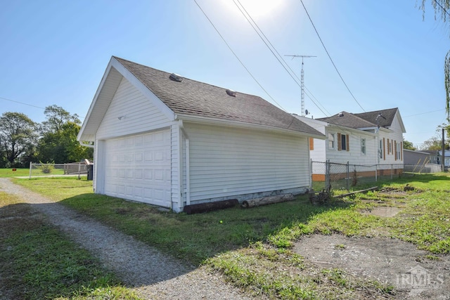 view of side of home featuring a yard and a garage