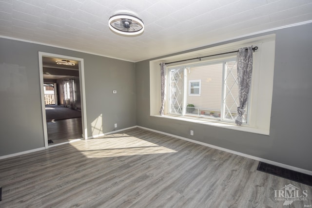 unfurnished room with wood-type flooring and crown molding