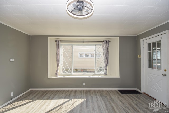 foyer entrance featuring ornamental molding, hardwood / wood-style floors, ceiling fan, and a wealth of natural light