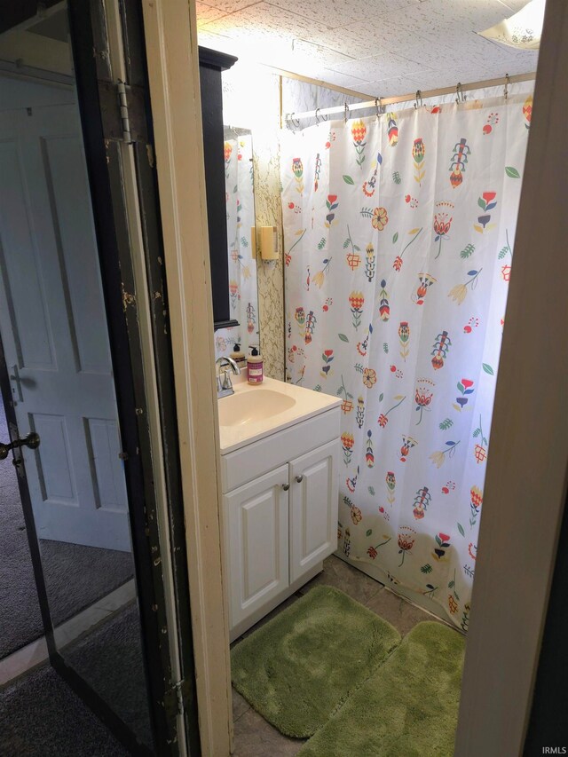 bathroom with shower / bath combination with curtain, vanity, and a textured ceiling