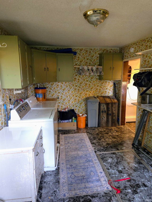 laundry area with cabinets, a textured ceiling, and washer and clothes dryer