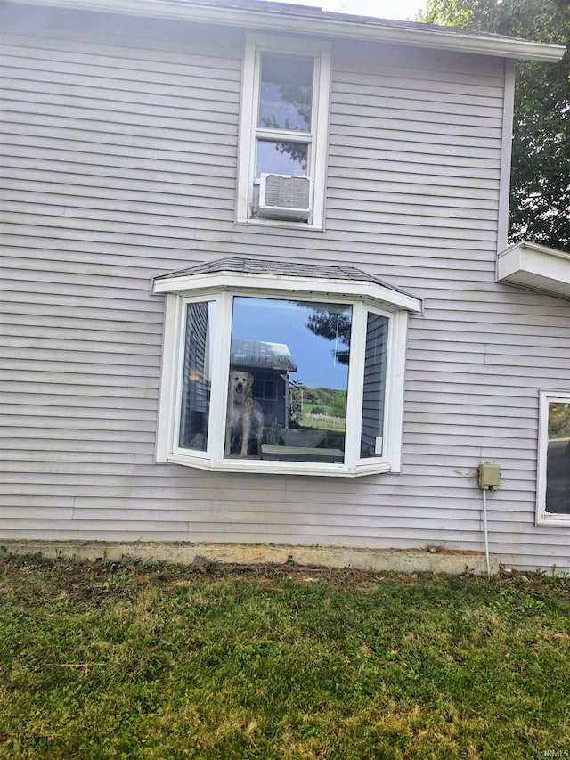 view of side of property with cooling unit and a yard