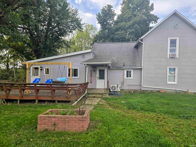 back of property with a wooden deck and a lawn