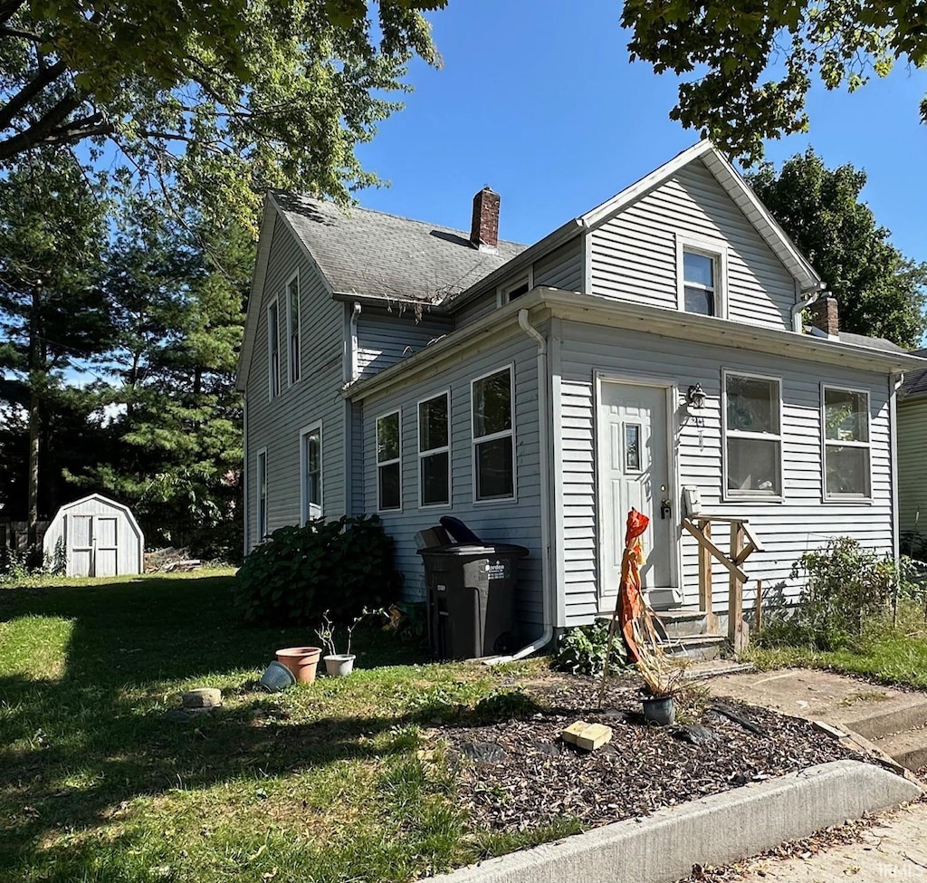 view of front facade with a storage shed and a front lawn