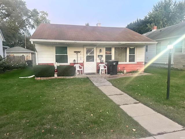 bungalow-style home featuring a front lawn