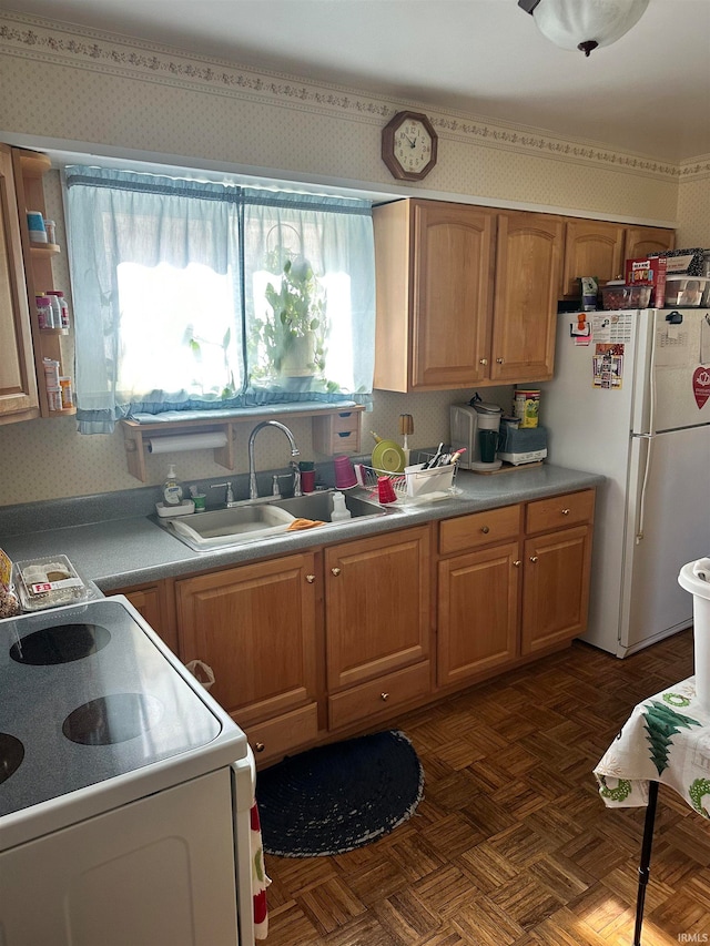 kitchen with sink, dark parquet floors, stove, and white refrigerator