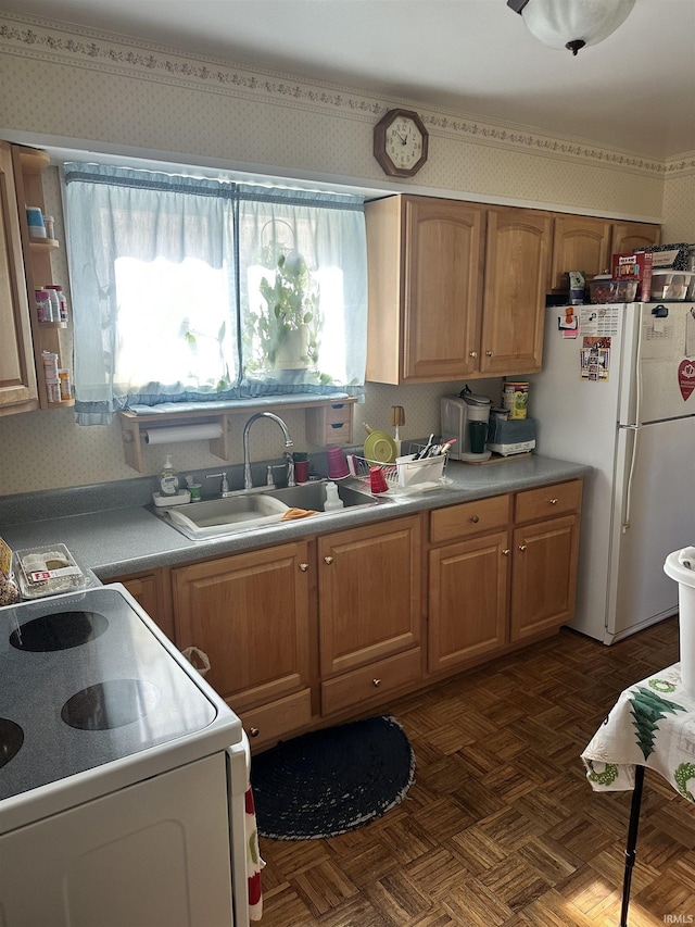 kitchen featuring white refrigerator, dark parquet flooring, range, and sink