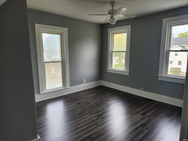 spare room featuring a textured ceiling, ceiling fan, and dark hardwood / wood-style flooring