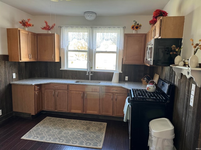 kitchen with black gas stove, sink, and dark wood-type flooring