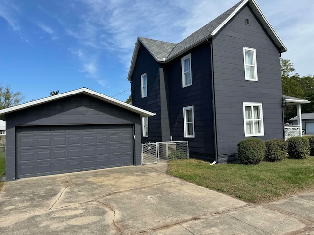 view of front facade featuring an outdoor structure, a garage, and a front lawn