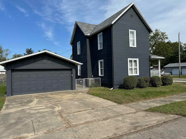 view of front of house featuring a garage and an outbuilding