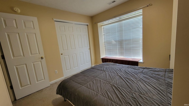 carpeted bedroom with multiple windows and a closet