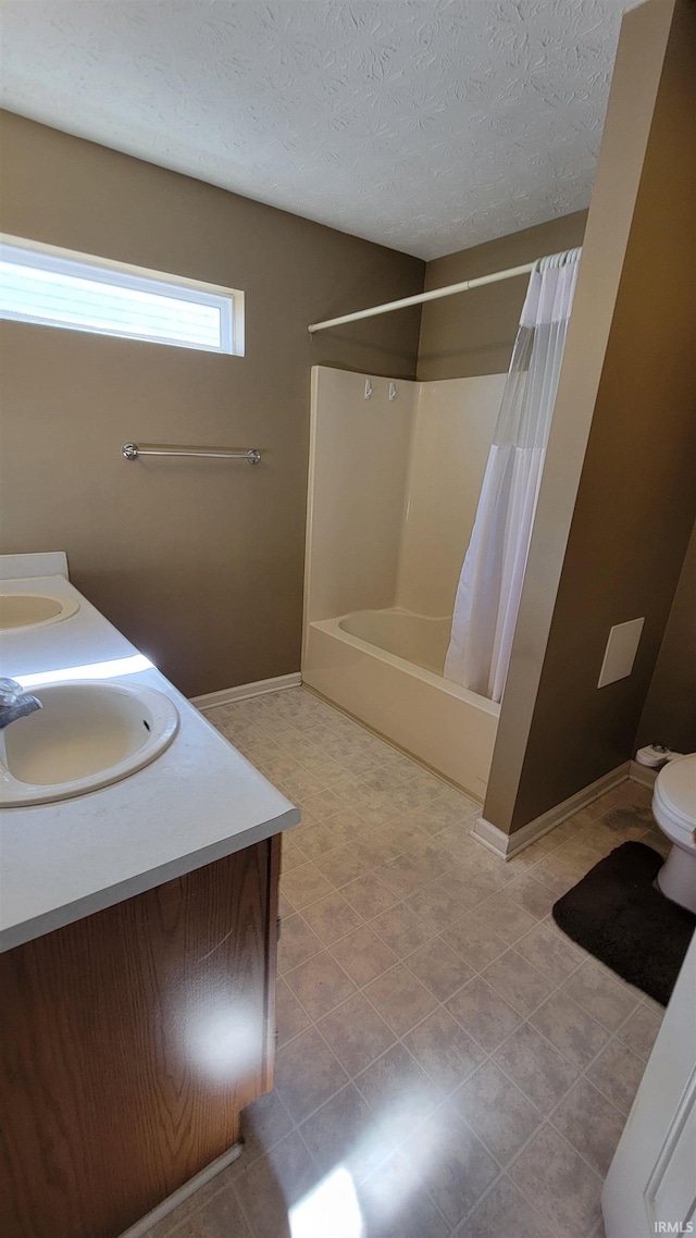 full bathroom with vanity, shower / bathtub combination with curtain, a textured ceiling, and toilet