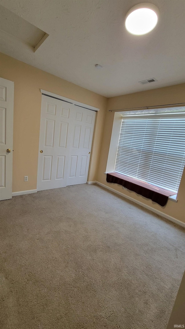 unfurnished bedroom featuring carpet flooring and a closet