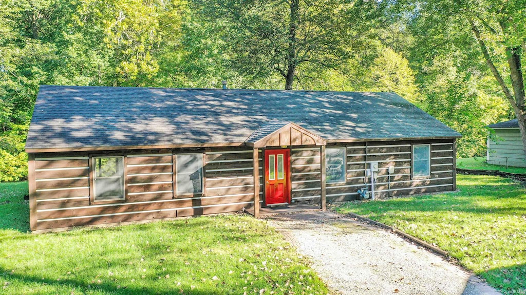 view of front of house with a front yard and an outbuilding