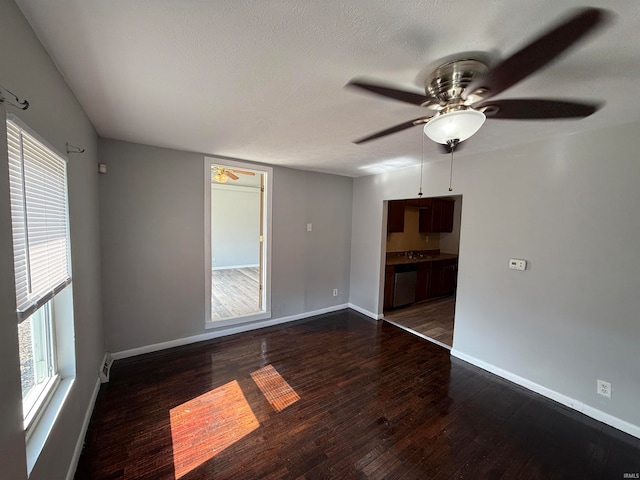 unfurnished room featuring a textured ceiling, ceiling fan, and dark hardwood / wood-style flooring