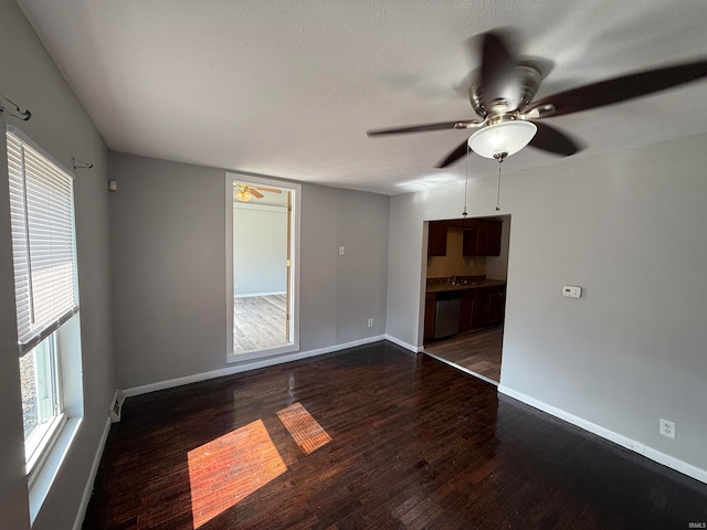 unfurnished room featuring ceiling fan, a textured ceiling, and dark wood-type flooring