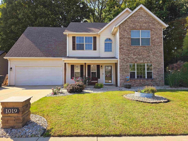 view of front of property featuring covered porch, a front yard, and a garage