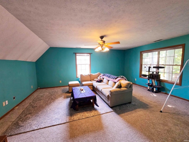 living room with a textured ceiling, carpet flooring, and plenty of natural light