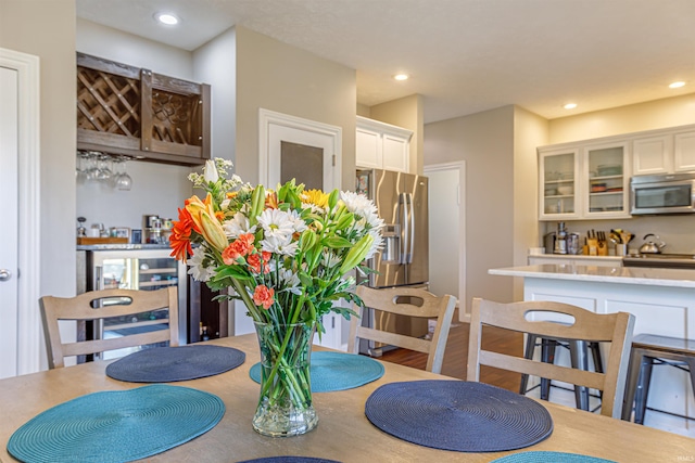 dining room with light hardwood / wood-style floors and bar area