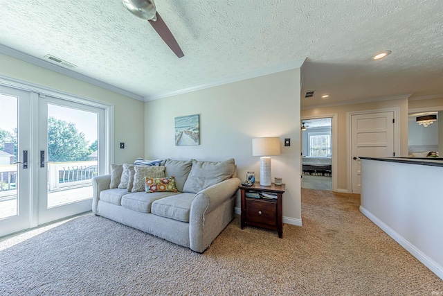 living room with light carpet, a wealth of natural light, a textured ceiling, and ceiling fan