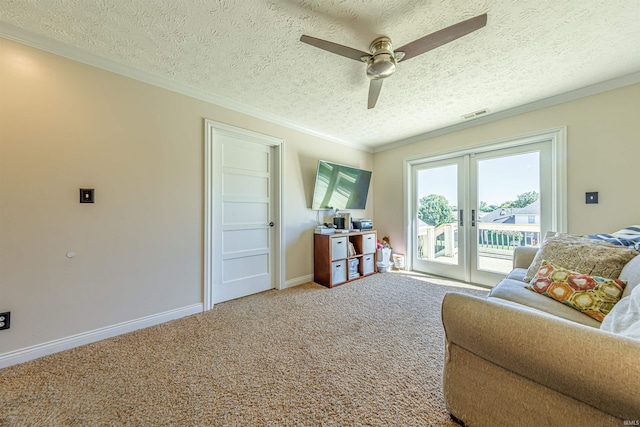 living room featuring a textured ceiling, carpet, ornamental molding, ceiling fan, and french doors