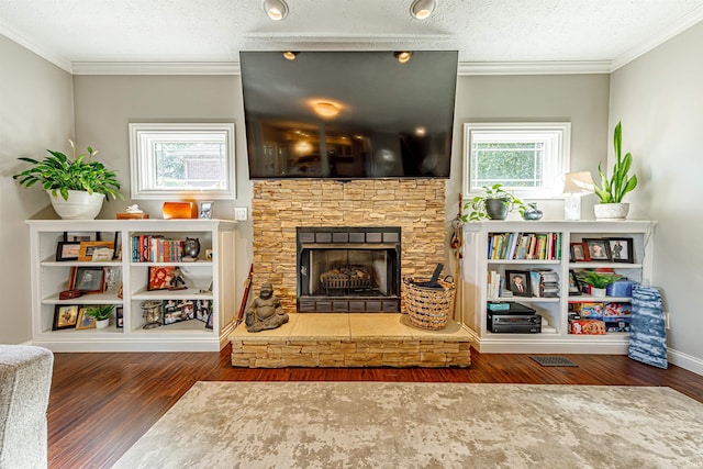 living room featuring a stone fireplace, a textured ceiling, crown molding, and dark wood-type flooring